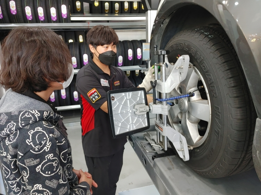 16일 서울 양천구 소재 타이어뱅크 김포공항점에서 김보경 사업주가 고객 차량 타이어를 점검하며 상태를 설명하고 있다.(사진=티어어뱅크)