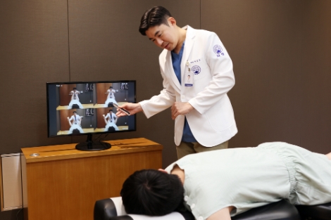 자생한방병원 이진호 병원장이 추나요법 전후 비교장치를 이용해 치료 상태를 환자에게 설명하고 있다. 사진=자생한방병원