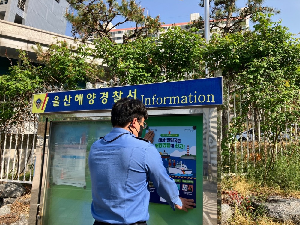 해상 밀입국 신고 홍보물을 부착하고 있다.(사진제공=울산해양경찰서)