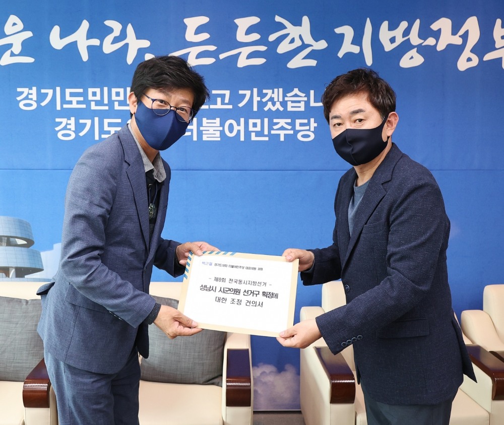 국중범도의원이 더불어민주당 박근철 대표의원에게 조정 건의서를 전달하고 있다.