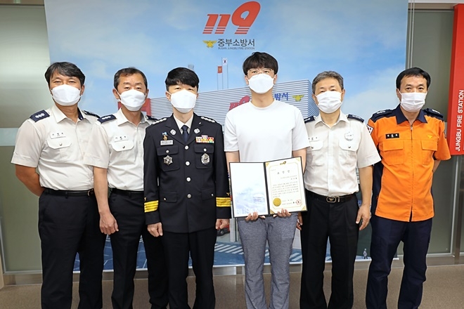 류승훈 부산중부소방서장이 화재집압 유공 이기병 씨에게 표창을 수여하고 직원들과 기념촬영.(사진제공=부산소방재난본부)