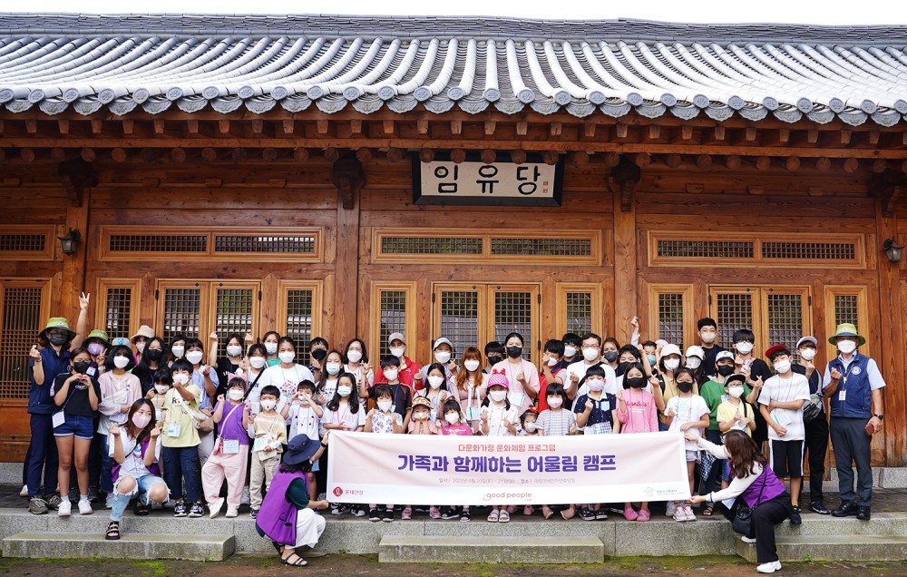 다문화 가족들이 ’다문화 어울림 가족 캠프’를 진행한 국립아세안휴양림 전통가옥 앞에서 단체사진을 찍고 있다.(사진=롯데건설)