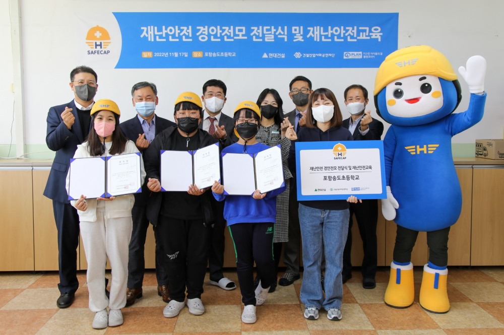 (왼쪽부터) 현대건설 문제철 상무, 건설산업사회공헌재단 오기종 부이사장, 송도초 교장선생님, (맨 오른쪽) 플랜코리아 김병학 본부장이 ‘재난안전 경안전모’ 전달식을 진행하고 있다.(사진=현대건설)