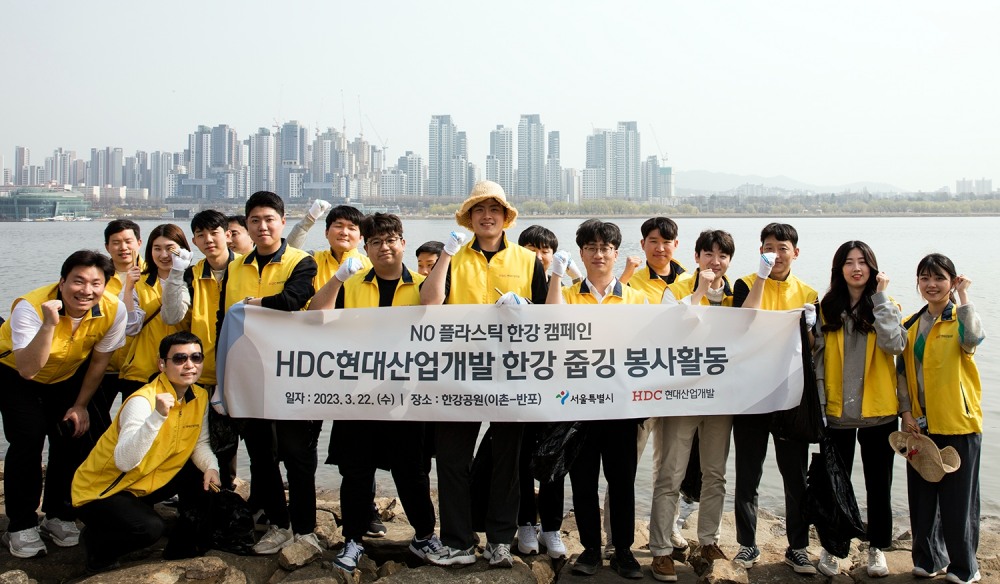HDC현대산업개발 임직원들이 이촌-반포 일대 환경을 정비하기 위한 한강 줍깅 봉사활동에 참여해 기념사진을 촬영하고 있다.(사진=HDC현대산업개발)