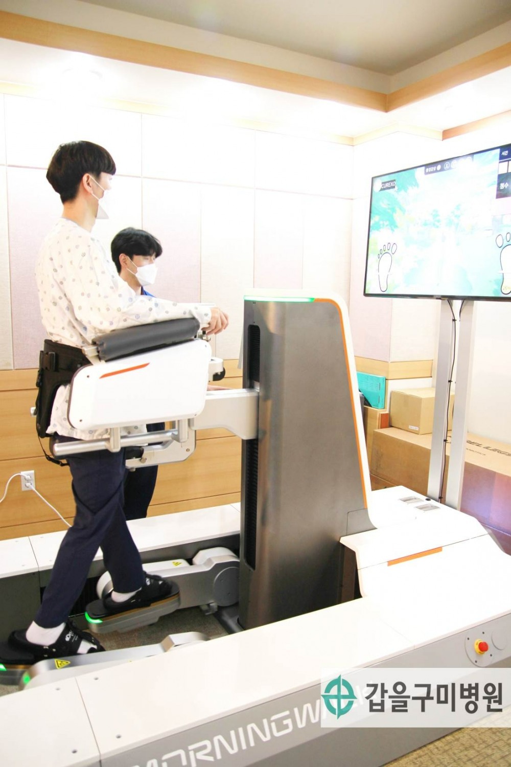 갑을구미병원의 로봇재활치료 센터에서 재활 환자가 발판기반형 보행재활로봇시스템으로 착석형 체중 지지방식을 이용해 평지걷기, 계단 오르내리기, 능동보행모드 등 다양한 보행훈련 모드를 선택하여 훈련하는 모습.(사진=갑을의료재단)