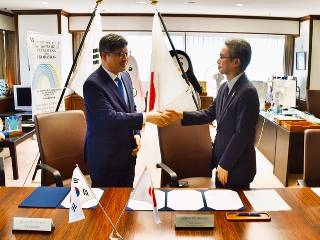 윤웅장 범죄예방정책국장(왼쪽)과 오시키리 히사토 일본 법무성 보호국장이 업무협약서에 서명을 하고 약수를 나누고 있다.(사진제공=법무부)