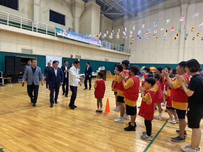 정종복 기장군수가 지역아동센터 연합체육대회 참석자들을 격려하고 아동에게 다가가 친근감을 표하고 있다.(사진제공=부산 기장군)