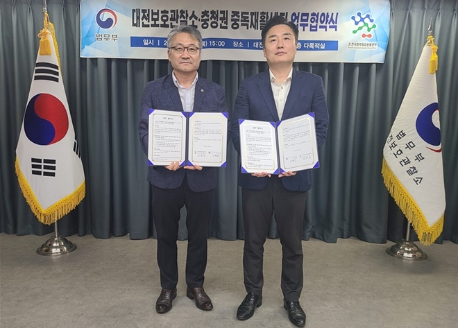 17일 보호관찰소 다목적실에서 마약퇴치운동본부 강원석 사무총장(사진왼쪽)과 대전보호관찰소 이형섭 소장이 업무협약서를 내보이며 기념촬영.(사진제공=대전보호관찰소)