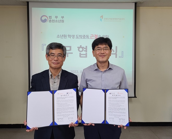 강원도박문제예방치유센터 장효강 센터장(사진왼쪽)과 춘천소년원 오상섭 원장이 업무협약서를 내보이며 기념촬영.(사진제공=춘천소년원)