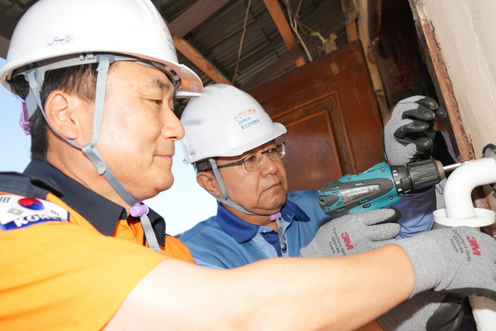 포스코이앤씨 한성희 사장(가운데)과 남화영 소방청장(왼쪽)이 7일 충북 음성의 60년이 넘은 노후세대를 방문해 주거환경개선활동를 진행하고 있다.(사진=포스코이앤씨)