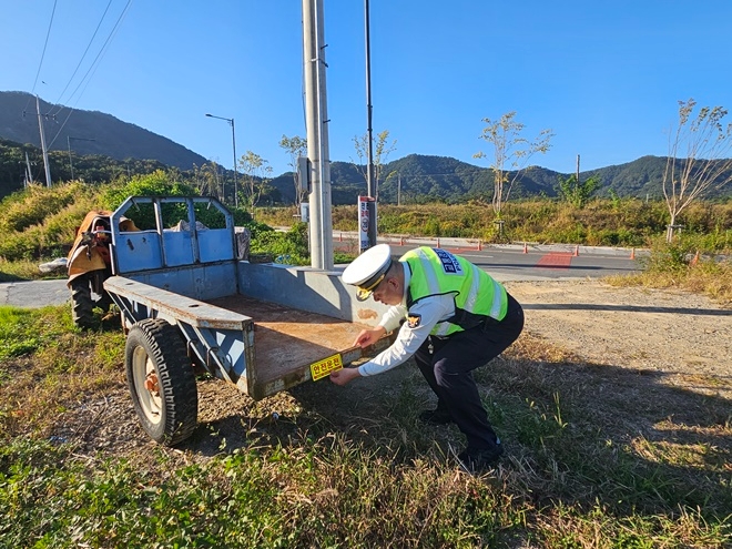 경찰이 경운기에 야간반사지를 부착하고 있다.(사진제공=김해서부경찰서)