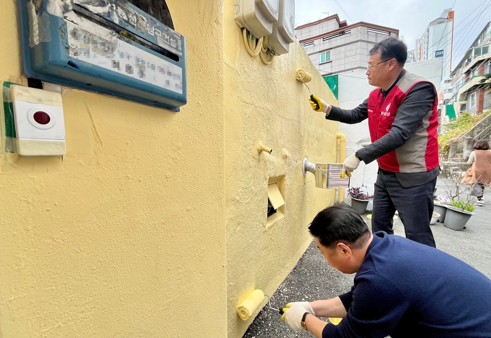 롯데건설 윤수준 영남지사장(위), 오은택 남구청장(아래)과 관계자들이 함께 외벽 도장 보수를 하고 있다.(사진=롯데건설)