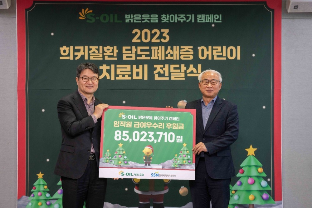 에쓰오일 김광남 부문장(왼쪽)과 한국사회복지협의회 김홍중 사무총장(오른쪽)이 21일 서울 마포구 공덕동 본사에서 열린 저소득가정 담도폐쇄증 어린이 치료비 전달식에서 기념사진을 찍고 있다.(사진=에쓰오일)