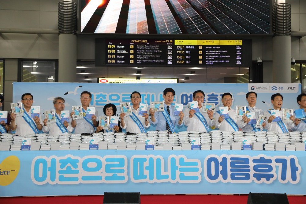 노동진 수협중앙회장이 16일, SRT 수서역에서 열린 '여름휴가 어촌에서 보내기 캠페인'에서 시민들에게 어촌 관광 안내 책자와 함께 수산물을 나눠주고 있다.(사진=수협중앙회)