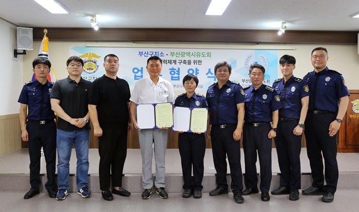 박수연 소장(우측 다섯번째)과 신득성 회장(왼쪽 네번째)이 업무협약서를 내보이며 기념촬영.(사진제공=부산구치소)