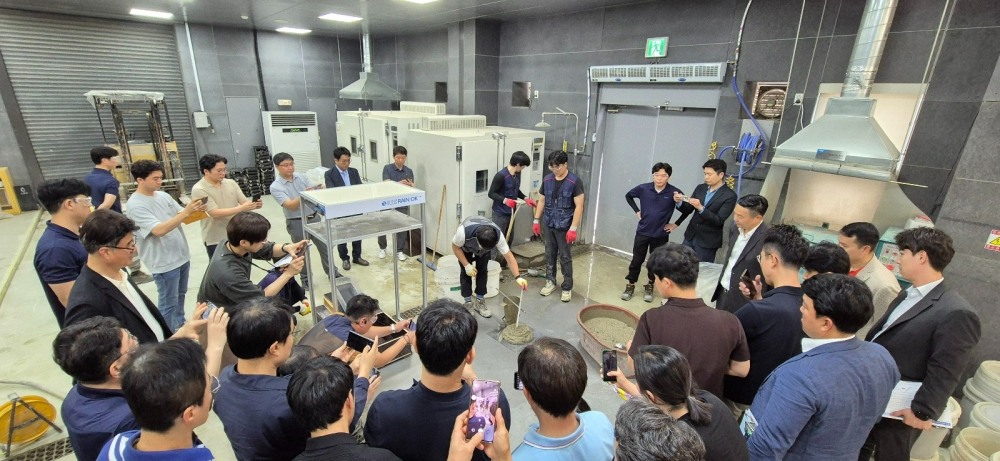 삼표산업 기술연구소에 진행한 ‘블루콘 Rain OK’ 시연회 현장에서 건설현장 감리를 비롯해 품질 실장 등 현장 관계자들이 콘크리트 강도 및 성능 실험을 지켜보고 있다. (사진=삼표그룹)