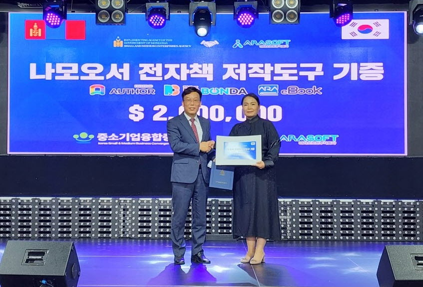 아라소프트(주) 강정현 대표(왼쪽)가 몽골 정부를 대리해 참석한 몽골 중소기업청 고위 관계자에게 전자책저작도구 나모오서 500라이선스 기증서를 전달하고 기념촬영을 하고 있다.