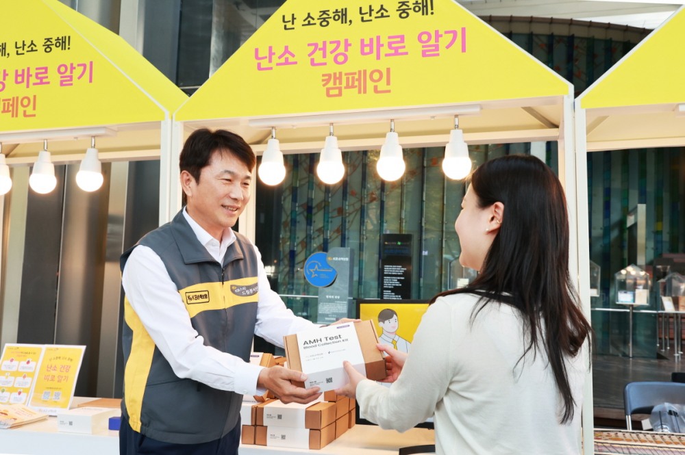 KB손해보험 본사 로비에서 KB손해보험 구본욱 사장(왼쪽)이 행사에 참여한 여성에게 난소 나이 자가검사 진단 키트를 전달하고 있다. 사진=KB손해보험