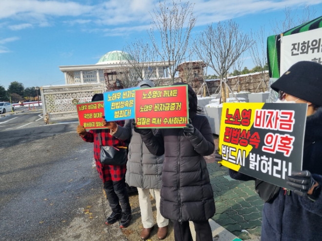 군사정권범죄수익국고환수추진위원회(이하 환수위)의 국회 앞에서 플랜카드를 들고 있는 모습. (사진=군사정권범죄수익국고환수추진위원회)