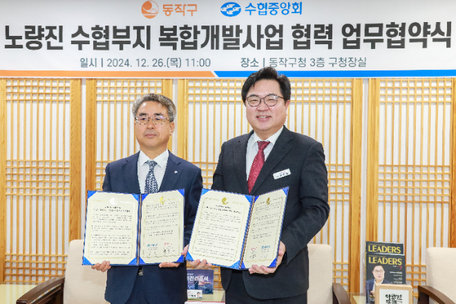 김기성 수협중앙회 지도경제대표이사(왼쪽)와 박일하 동작구청장이 지난 26일 노량진 일대를 서울 랜드마크로 조성하기로 약속하는 ‘노량진 수협부지 복합개발사업 협력’ 업무협약을 체결한 뒤 협약서를 들고 기념촬영을 하고 있다.(사진=수협중앙회)