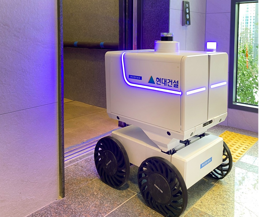 엘리베이터 무인 승하차 기능이 탑재된 자율주행 로봇이 서비스를 운행하고 있다.(사진=현대건설)