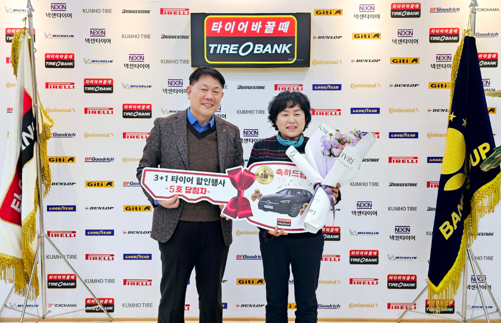 세종특별자치시 어진동에 위치한 타이어뱅크 본사에서 5회차 1등으로 당첨 된 윤경숙씨(우)와 타이어뱅크 김정규 회장(좌)이 축하 행사를 진행하고 기념 촬영을 하고 있다.(사진=타이어뱅크)