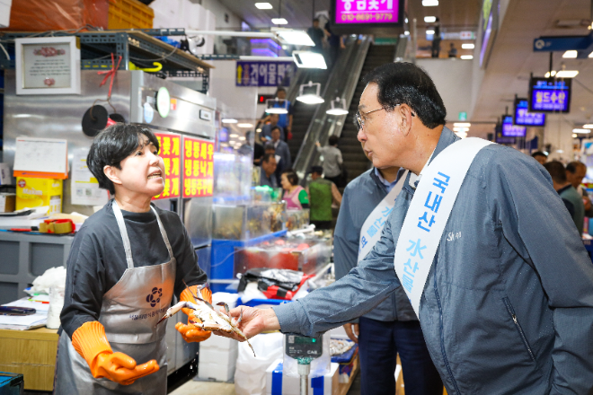 노동진 수협중앙회장(오른쪽)이 지난해 9월 4일 노량진수산시장을 찾아 매주 수요일마다 제철 수산물을 최대 30% 싸게 판매하는 '노량진 수산데이'에 참여한 상인과 얘기를 나누고 있다.(사진=수협중앙회)
