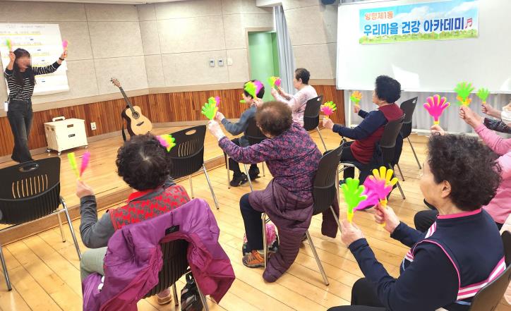 어르신들이 손바닥 짝짝이를 흔들며 리듬을 맞추고 있는 모습