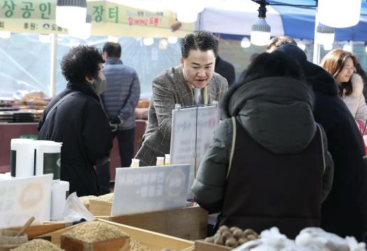 오언석 도봉구청장(가운데)이 지난 2월 창동역 하부에서 열린 소상공인 정월대보름 행복장터에서 물건을 구입하고 있다