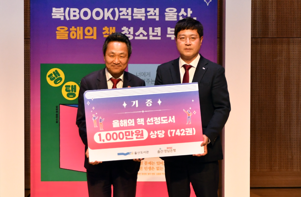 BNK경남은행 이하수 팀장(사진 오른쪽)이 울산광역시 안승대 행정부시장에게 ‘도서 기증서’를 전달하고 있다. 사진=BNK경남은행