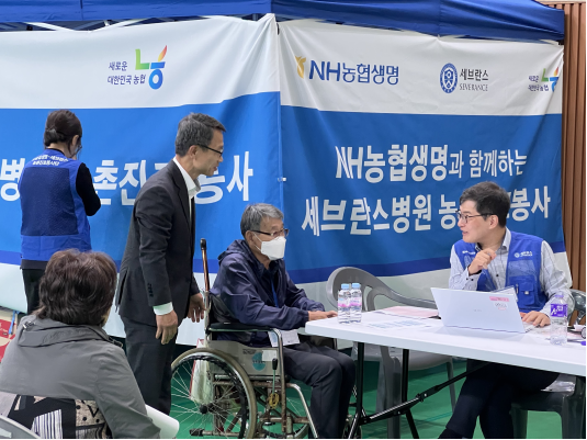 진받는 조합원을 살피는 NH농협생명 김기동 부사장의 모습. 사진=NH농협생명