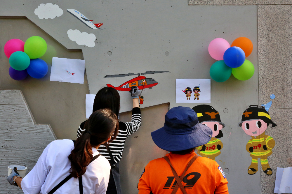 서울 광진구 능동 광나루안전체험관에서 티웨이항공 임직원과 소방관이 벽화 그리기 봉사활동을 진행하고 있다.(사진=티웨이항공)