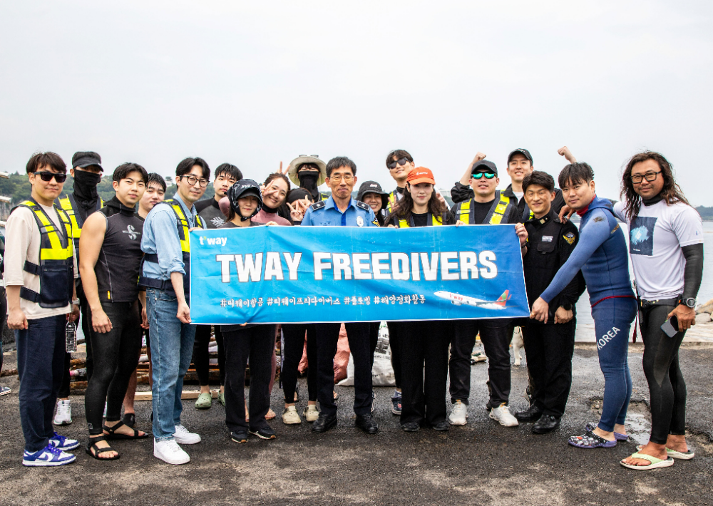 지난 5월 31일(토) 제주도 서귀포항 해안가에서 진행된 해양 정화 활동 후 티웨이항공 프리다이버스와 박상춘 제주지방해양경찰청장(가운데), 전장원 플로빙코리아 대표(오른쪽에서 첫 번째)가 기념 사진을 촬영하고 있다.(사진=티웨이항공)