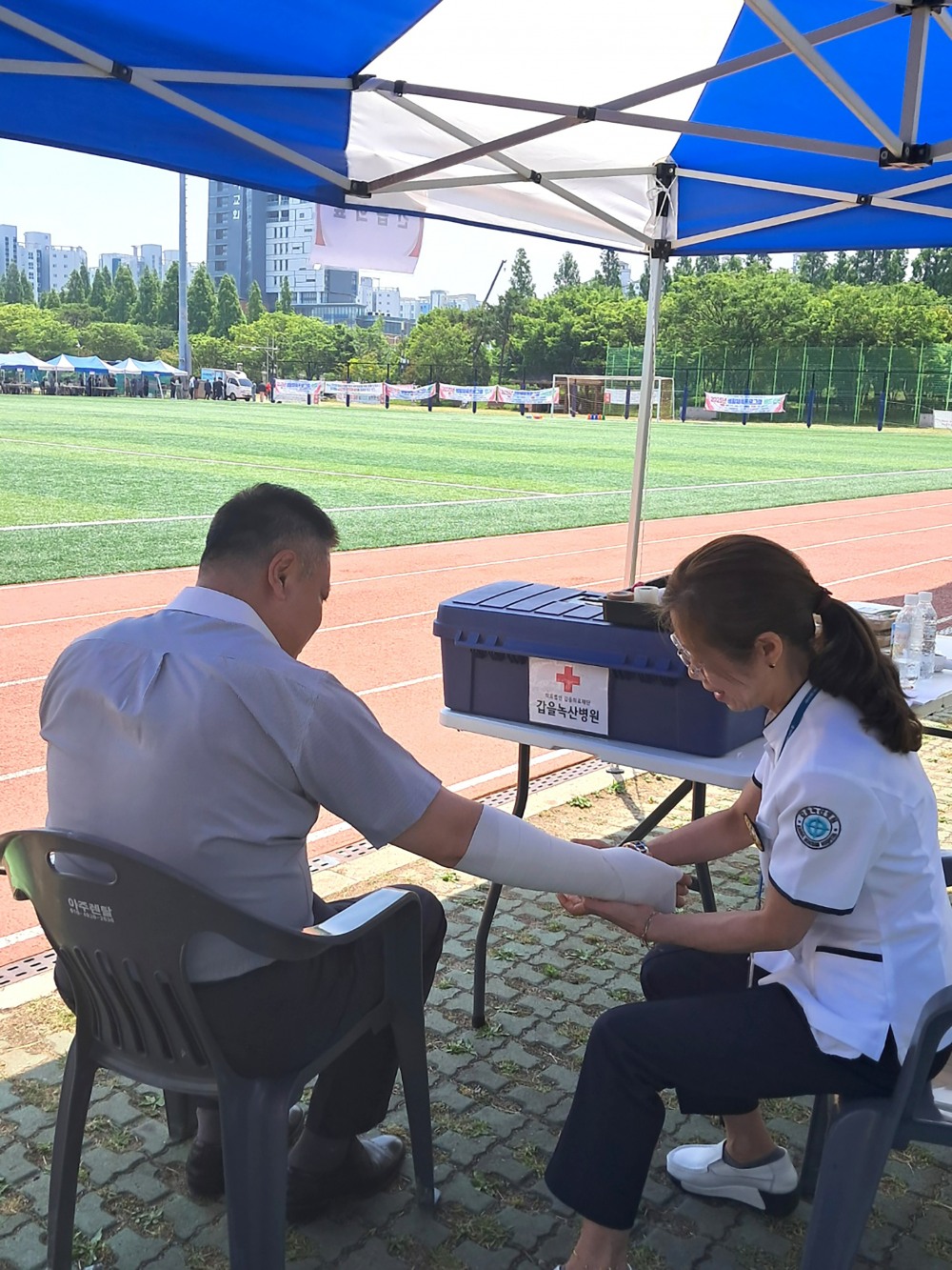 갑을녹산병원 의료팀이 지난 10일 「제3회 강서구 장애인 체육 대축전」에서 경기 중 부상당한 참가자를 치료하고 있다.(사진=KBI그룹)