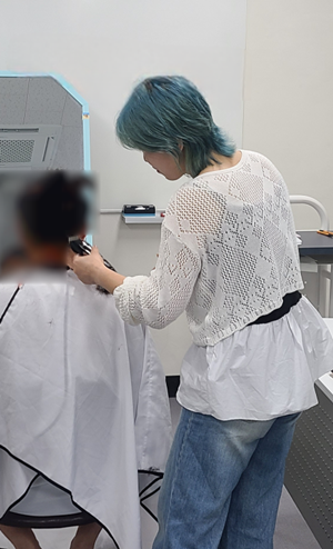 숙식대상자를 위해 이미용 봉사를 하고 있는 한승연 원장.(제공=한국법무보호복지공단 전남동부지부)