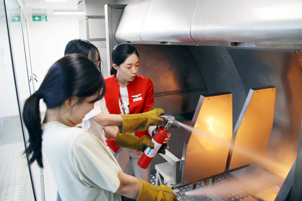 지난 8일 오후 티웨이항공 훈련센터에서 객실 승무원 체험 활동에 참여한 속초양양지역 중학생들이 화재진압 훈련을 체험하고 있다.(사진=티웨이항공)