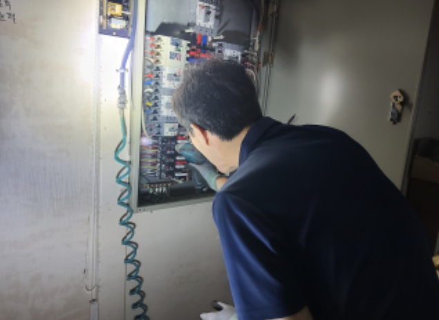 안전점검 전문업체가 봉제업체에서 분전반 안전점검을 실시하는 모습