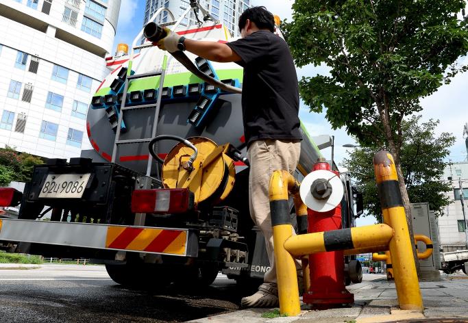 성동구청 관계자가 강릉시로 지원하는 급수차를 살피고 있는 모습