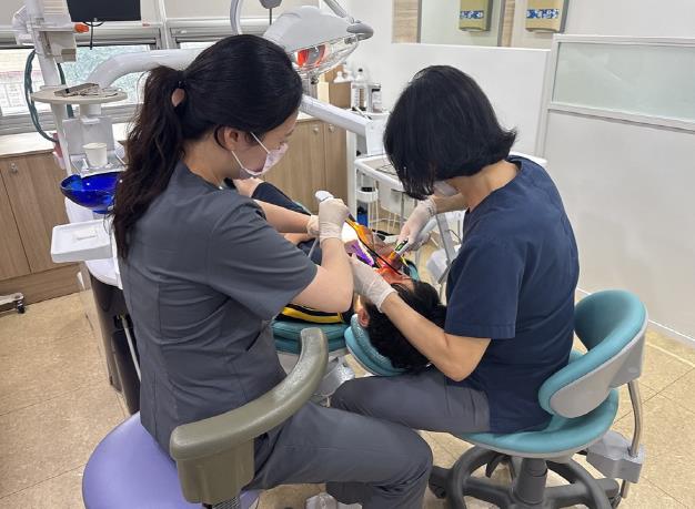 초등학생이 치과 의료기관에 방문하여 구강 관리를 받고 있다.