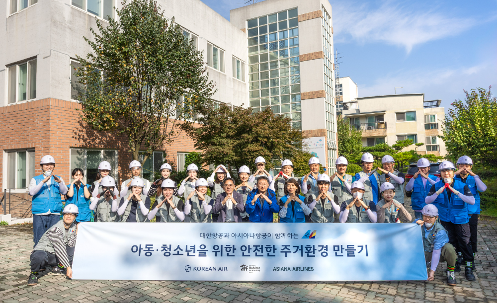 봉사활동에 참여한 대한항공-아시아나항공 양사 임직원 20여 명이 노후화된 벽지 교체 등을 지원하고 기념사진을 촬영하는 모습.(사진=대한항공)