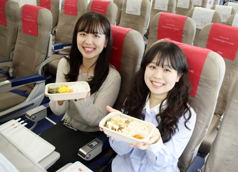 티웨이항공 탑승객이 신규 펄프 몰드 소재로 만든 용기가 적용된 기내식을 맛보고 있다.(사진=티웨이항공)