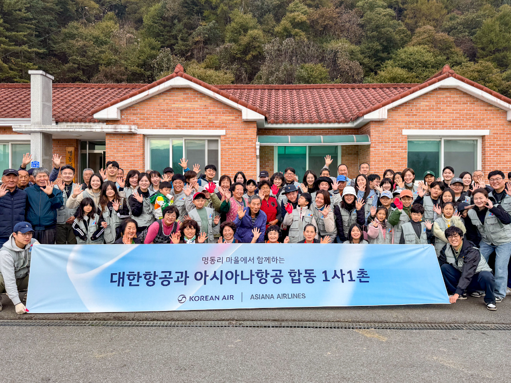 봉사활동에 참여한 대한항공·아시아나항공 양사 임직원과 가족들이 명동리 주민들과 기념사진을 촬영하는 모습.(사진=대한항공)