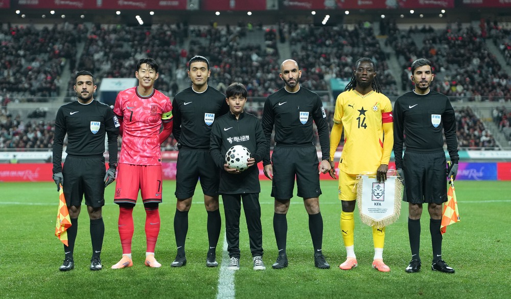 하나은행은 지난 18일 서울월드컵경기장에서 열린 대한민국과 가나의 축구 국가대표팀 A매치 경기에서 이주배경 가정 아동·청소년들에게 '매치볼 키드'와 '기수단'으로 참여할 수 있는 특별한 체험 기회를 제공했다고 밝혔다.이날 경기 시작에 앞서 아프가니스탄 출신 '매치볼 키드' 마시(Masih)가 양 팀 주장 및 심판진과 함께 기념촬영을 하고 있다. 사진=하나은행