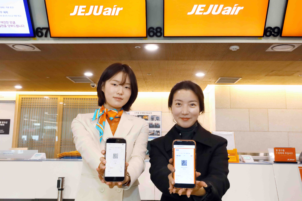 김포공항 국내선 청사 제주항공 카운터에서 제이에이에스(JAS) 직원과 탑승객이 발급 받은 모바일 탑승권을 들어 보이고 있다.(사진=제주항공)