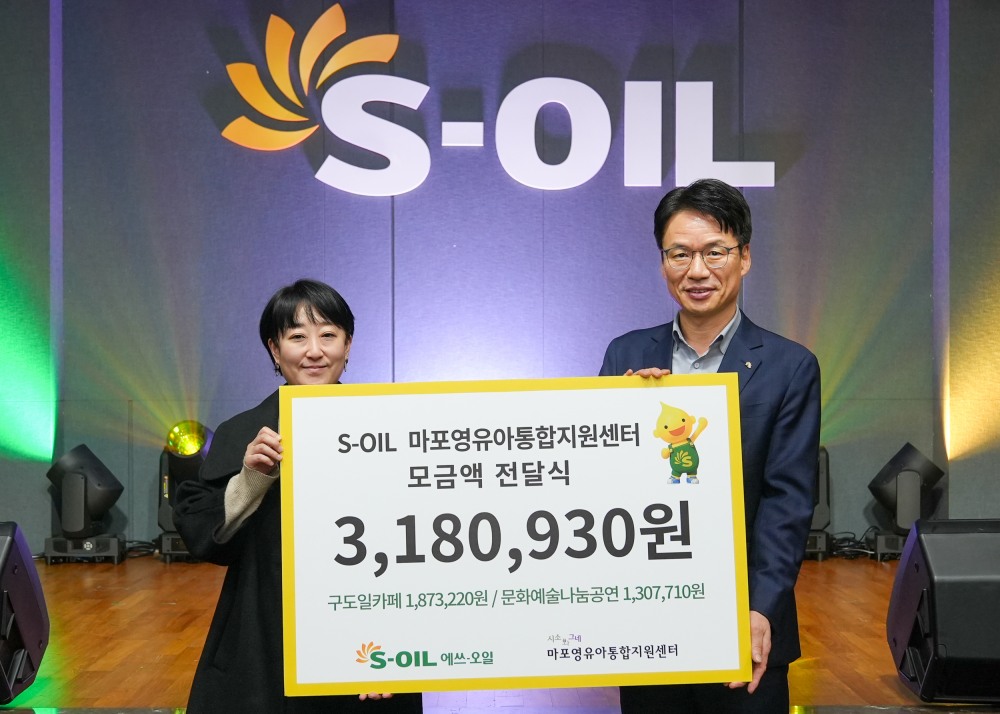 S-OIL 서경섭 부문장(오른쪽)이 마포영유아통합지원센터 ‘시소와그네’ 임명연 관장(왼쪽)에게 모금액을 전달하고 기념 촬영을 하고 있다.(사진=에쓰오일)