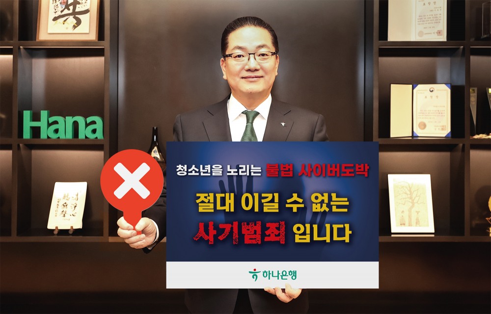 이호성 하나은행장이 서울 중구 하나은행 을지로 본점에서 청소년 불법도박 근절 릴레이 캠페인에 동참하기 위해 '청소년을 노리는 불법 사이버 도박, 절대 이길 수 없는 사기 범죄입니다'라는 메시지를 담은 피켓을 들고 사진을 촬영하고 있다. 사진=하나은행