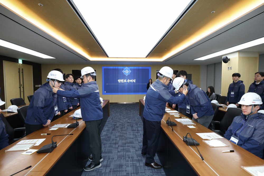 김보현 대표이사(왼쪽)와 심상철 노동조합 위원장(오른쪽)이 신입사원에게 안전모를 씌워주고 있다.(사진=대우건설)