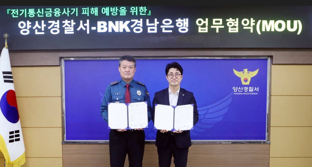 BNK경남은행 조필호 금융센터장(사진 오른쪽)과 양산경찰서 김종규 서장이 ‘전기통신 금융사기 피해 예방을 위한 업무 협약’을 체결하고 있다. 사진=BNK경남은행