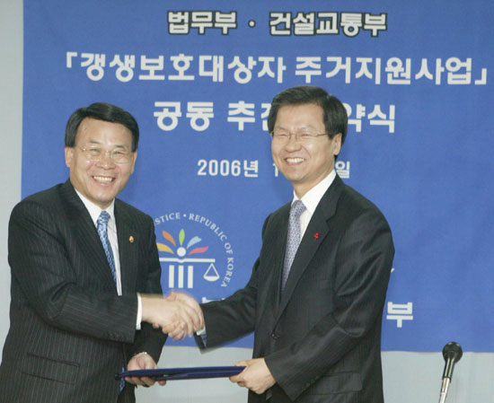 ▲천정배법무부장관(우)과추병직건설교통부장관(좌)이조인식을갖고악수를나누고있다.