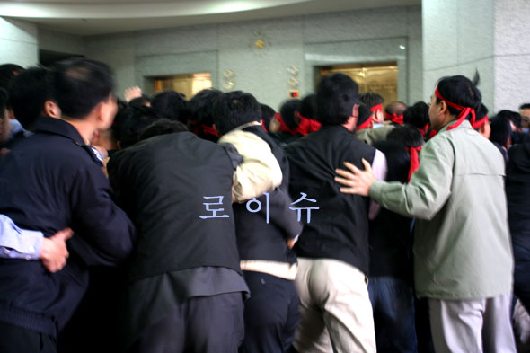 ▲법원노조원들이대법원장실로이동하려하자법원경비대원이이를가로막으며물리적충돌이빚어졌다.
